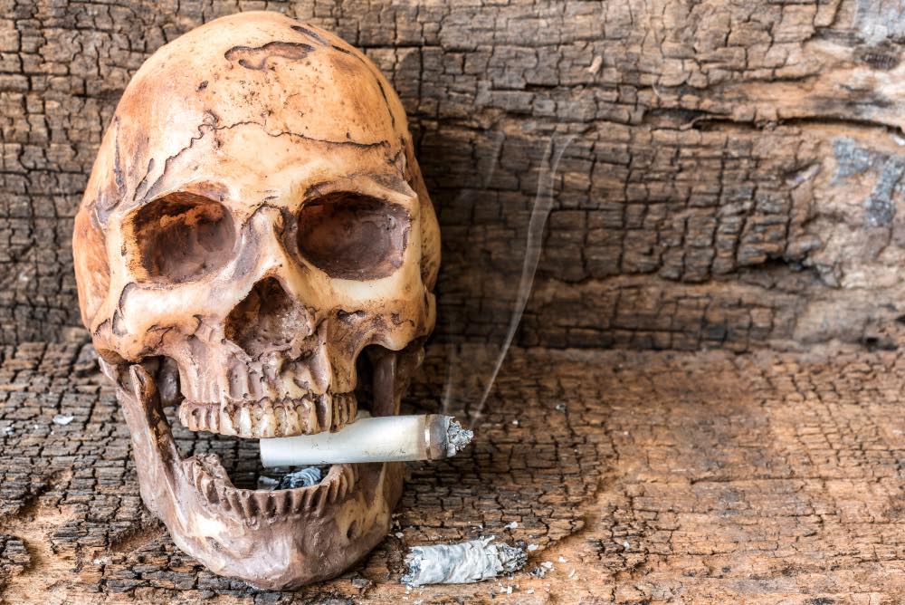 human skull smoking cigarette with smoke